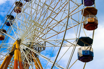 Ferris wheel in amusement park is large on the sky background