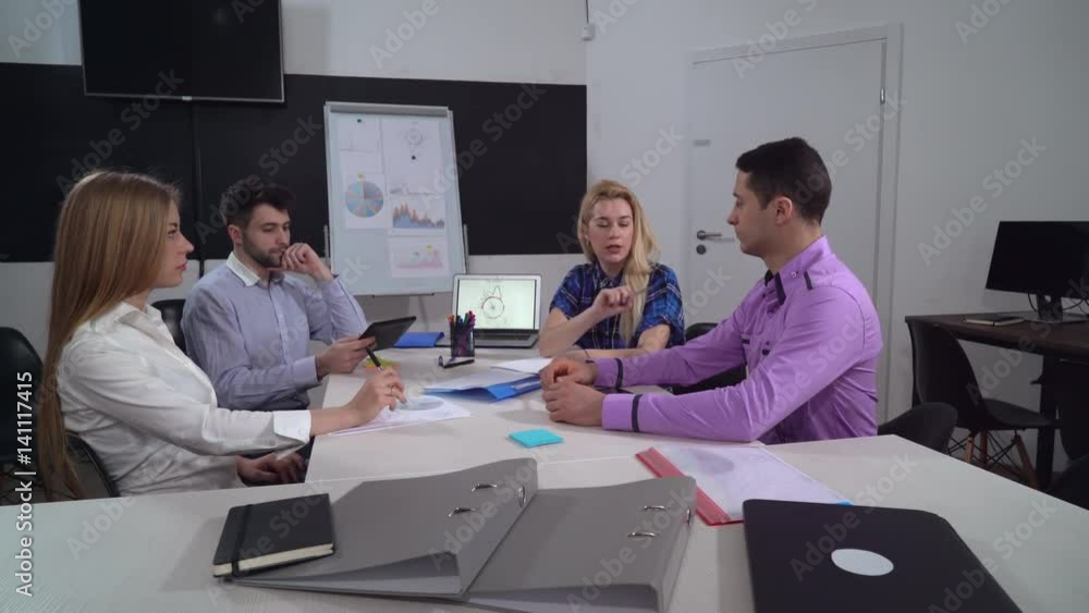 Aufkleber young diverse business team sitting in the boardroom. group of people discussing new project holding