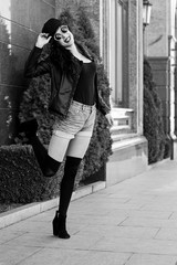 Stylish modern woman in old part of city in short shorts and a leather jacket