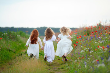 three kid girls in white dresses running out outdoors. Playing children