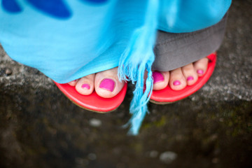 Female feet in sandals on stone steps closeup
