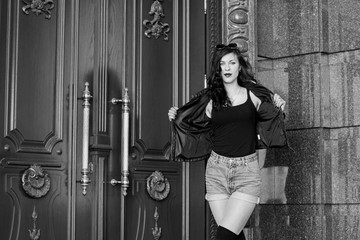 Stylish modern woman in old part of city in short shorts and a leather jacket