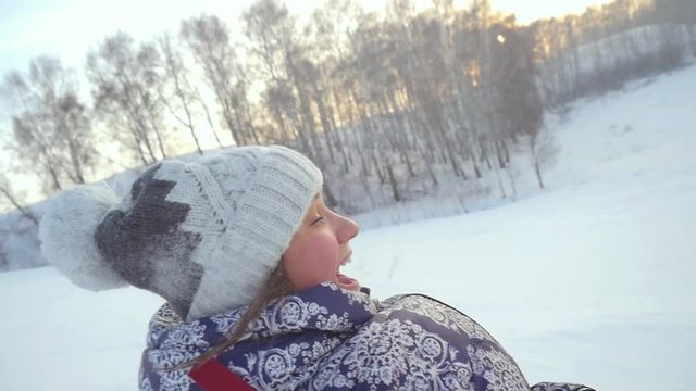Young happy woman is sledding from the mountain through the snow in slow motion during beautiful sunset. 1920x1080