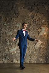 Obraz na płótnie Canvas young businessman in blue suit emotional posing
