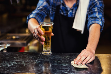 Bartender pouring the fresh beer in pub,barman hand at beer tap pouring a draught lager beer,beer from the tap,Filling glass with beer,fresh beer,pub.Bar.Restaurant.European bar.American bar.