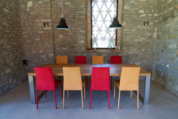 table with colored chairs in a rustic loft