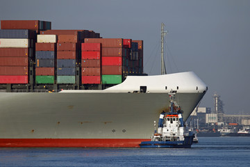 Hafenschlepper am Containerschiff