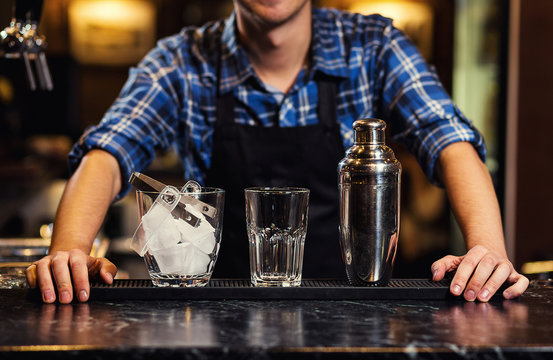 Barman at work,Barman pouring hard spirit into glasses in detail,Bartender is pouring tequila into glass,preparing cocktails,concept about service and beverages