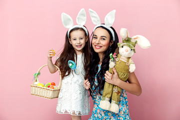 easter, family, holiday and child concept - close up portrait of little girl and mother coloring eggs for easter