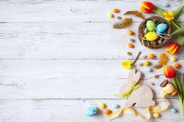 Spring easter wooden background with eggs, candy and flowers