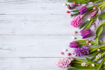 Spring easter wooden background with eggs, candy and flowers