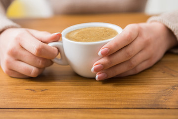 Close-up of woman with cup of coffee in cafe