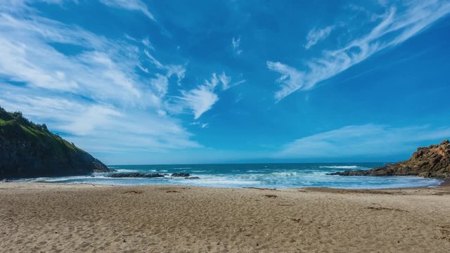 Time lapse of sandy beach with waves and clouds