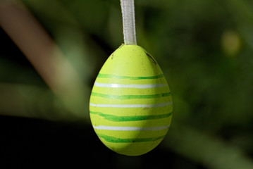 Colorful Eastern eggs hanging between flowers in the garden