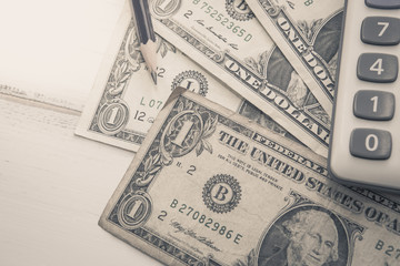 Calculator with american dollars on the wooden table background, finance concept