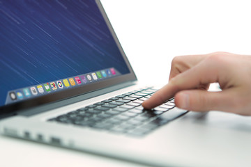 Hand typing on a keyboard of laptop with operating system screen on background