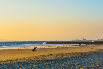 Fototapeta na wymiar surfer walking on the sand