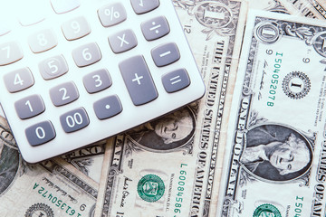 Fototapeta premium Calculator with american dollars on the wooden table background, finance concept