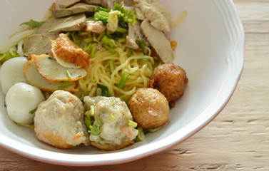 Chinese egg noodles topping shrimp ball and slice boiled pork on bowl
