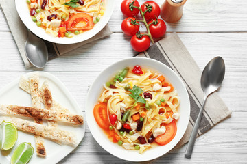 Chicken tortilla soup in plate on wooden table