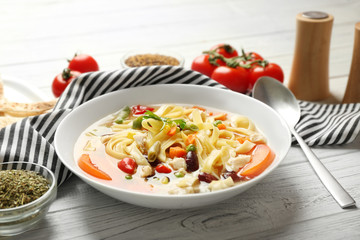 Chicken tortilla soup in plate on wooden table