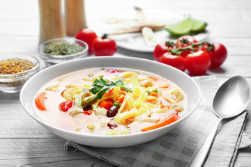 Chicken tortilla soup in plate on wooden table
