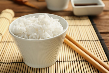 Bowl of rice and chopsticks on bamboo mat