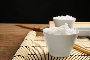 Bowl of rice and chopsticks on bamboo mat