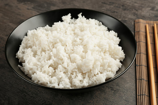 Bowl of rice on color background