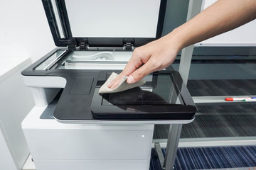 close up businessman clean touch screen of office printer for maintenance