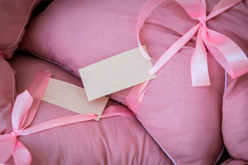 delicate pink satin pillow with a tag tied to the bow