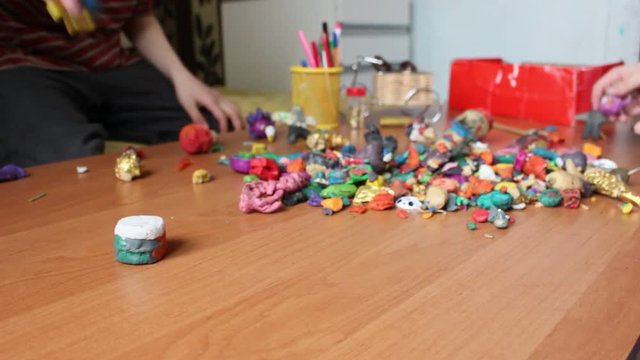 Children moulding animal figurines from multicolour clay in playroom