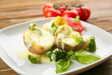 Portion of delicious baked potato with cheese sauce, closeup