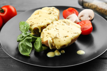 Portion of delicious baked potato with cheese sauce