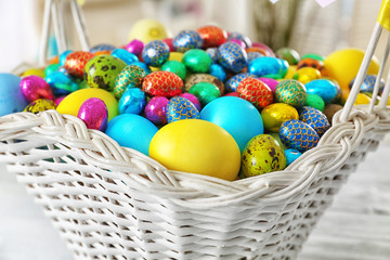 Fototapeta na wymiar Easter basket with colorful eggs on table, closeup