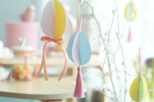 Easter tree made of painted pussy willow and colorful paper eggs on blurred background