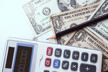 Calculator with american dollars on the wooden table background, finance concept