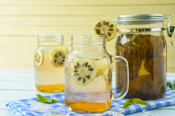 Noni herbal juice glass and noni fermented on Blue checkered fabric