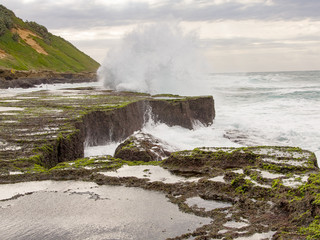 Spray and breaking wave at spring-low tide at Reunion Rocks south of Durban.
