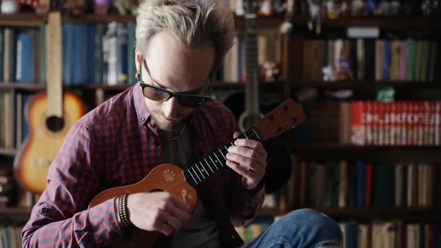 Man Playing mini Acoustic Guitar in sun glass.