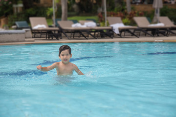 Naklejka premium 4 years old Asian kid swimming lonely in clean swimming pool at sport club