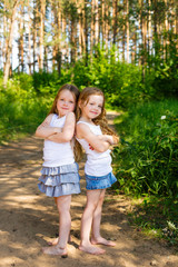 Fototapeta premium Two little girl girl friends hugging in the forest
