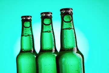 Closeup of three green beer bottles neck