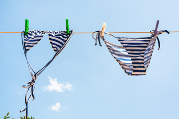 blue Striped swimsuit is dried on clothesline