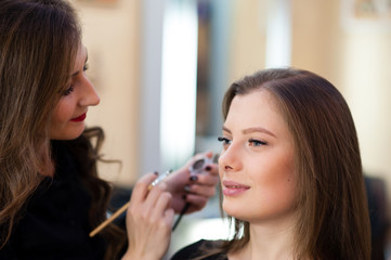 Obraz na płótnie Canvas Makeup artist makes beautiful girl makeover