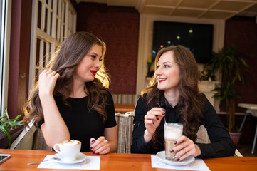 Two beautiful girls drinking coffee
