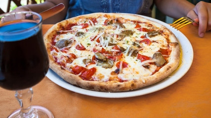 girl eats pizza with fungi in restaurant
