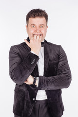 business man biting his nails fingers freaking out. human emotion expression and lifestyle concept. image on a white studio background..