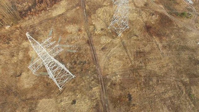 
4K .Aerial. Power line tower in field. Camera raising
