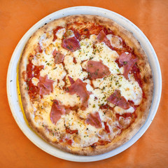 top view of pizza with prosciutto on plate